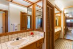 A large bathroom is connected to the bedroom and features twin vanities with sinks